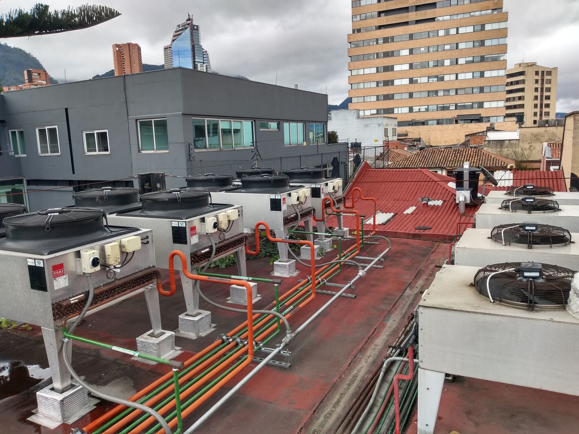 Condensadoras de climatización de precisión instaladas en una cubierta, con la ciudad de Bogotá al fondo